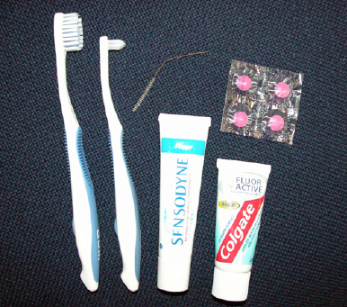  forskellige typer tandbørster, tandpasta og røde farvetabletter
